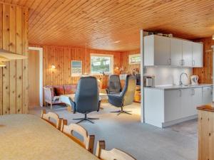 a living room with chairs and a kitchen and a table at Holiday Home Steni - 250m from the sea in Western Jutland by Interhome in Vejers Strand