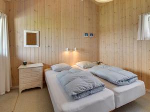 Habitación con 2 camas, paredes de madera y mesa. en Holiday Home Steni - 250m from the sea in Western Jutland by Interhome en Vejers Strand