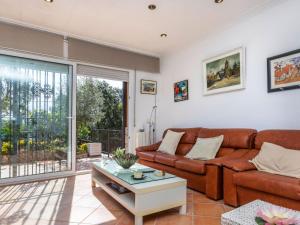 een woonkamer met een bank en een tafel bij Holiday Home Aguilera by Interhome in Maçanet de la Selva