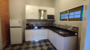 a kitchen with white cabinets and a black counter top at Taguato Recoleta in Asunción