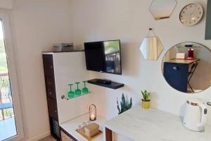 a room with a refrigerator and a counter with a mirror at MANHATTAN Studio Balcon Ensoleillé Parking Nord Montpellier in Grabels
