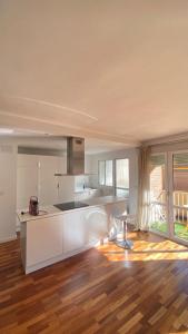 cocina con armarios blancos y suelo de madera en Apartamento centro de Granada, en Granada