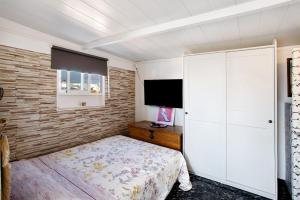 een slaapkamer met een bed en een flatscreen-tv bij Casa Patricia in Vecindario