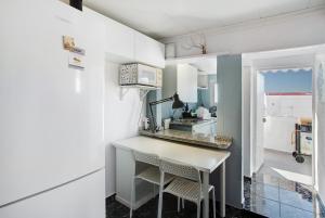 una pequeña cocina con encimera blanca y taburetes en Casa Patricia en Vecindario