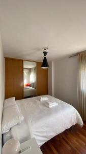1 dormitorio con 1 cama blanca grande y espejo en Apartamento centro de Granada, en Granada