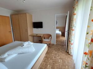a bedroom with a bed and a desk and a television at Apartment Lilie by Interhome in Velden am Wörthersee