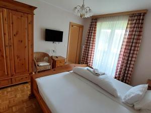 a bedroom with a bed and a television and a window at Apartment Lilie by Interhome in Velden am Wörthersee