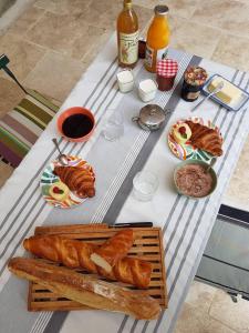 una mesa con pan y otros alimentos. en domaine de Capoulade, en Narbona