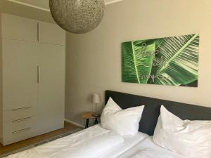 Un dormitorio con una cama con almohadas blancas y una planta en Gartenhaus5, en Bad Tatzmannsdorf