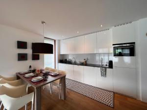 a kitchen with a wooden table and white cabinets at Apartment Residence Bellevue by Interhome in Zell am See