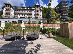 a patio with two chairs and umbrellas in front of a building at Apartment Residence Bellevue by Interhome in Zell am See