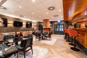 eine Lobby mit einer Bar sowie Tischen und Stühlen in der Unterkunft Van der Valk Hotel Berlin Brandenburg in Blankenfelde