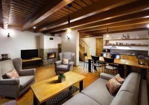 a living room with a couch and a dining room at Chalets Jasná Collection Záhradky in Demanovska Dolina
