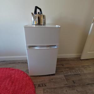 a white refrigerator with a tea kettle on top of it at EnSuite Room with private shower, walking distance to Harry Potter Studios in Leavesden Green