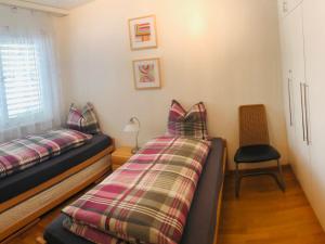 1 Schlafzimmer mit 2 Einzelbetten und einem Stuhl in der Unterkunft Apartment Edelweiss C by Interhome in Leukerbad