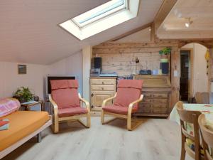 a living room with two chairs and a desk at Apartment Beim Thor by Interhome in Brienzwiler