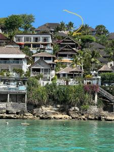 un grupo de casas en una colina junto al agua en Villa Atas Lembongan, en Nusa Lembongan