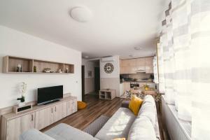 a living room with a couch and a tv at D&B Lelle Apartman in Balatonlelle +11 photos