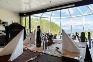 a table with wine glasses and wine bottles on it at Kleivstua Hotel in Sundvollen