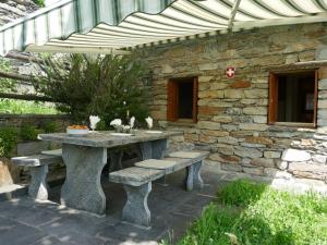 Semione的住宿－Holiday Home Rustico Casa Cleo by Interhome，石墙前的石桌和长凳