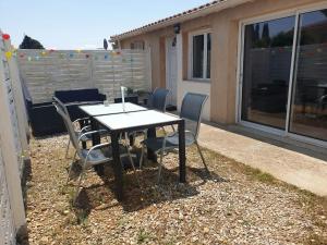 une table et des chaises assises sur une terrasse dans l'établissement Canal du Midi Argeliers Gîte 4 personnes, à Argeliers