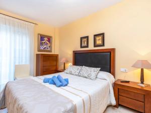 Un dormitorio con una cama grande con almohadas azules. en Apartment Mirador de Llandels II by Interhome, en Peñíscola