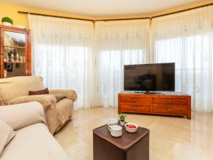 Una sala de estar con un sofá y un televisor de pantalla plana. en Apartment Mirador de Llandels II by Interhome, en Peñíscola