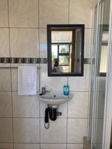 a man taking a picture of a sink in a bathroom at Mercy Land Guesthouse in Matatiele +11 photos