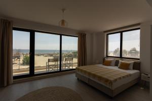 a bedroom with a bed and a large window at Milena in Mamaia Sat/Năvodari