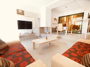 a living room with a couch and a tv and a table at Villa Villa Perla by Interhome in Bonmont Terres Noves