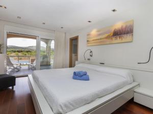 a bedroom with a white bed with a blue towel on it at Villa Finca Villa Roig by Interhome in Peniscola