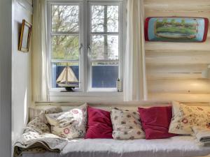 - un canapé avec des oreillers dans une chambre avec une fenêtre dans l'établissement Holiday Home Gunnhild - 500m from the sea in Sealand by Interhome, à Gilleleje