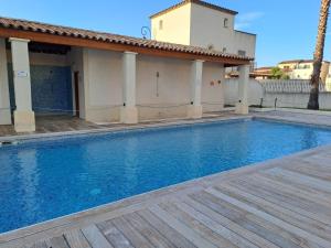 una piscina frente a una casa en Belle marina avec ponton et piscine collective, en Aigues-Mortes