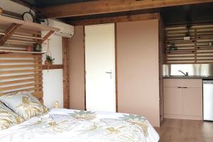 Cet appartement comprend une chambre avec un lit et une cuisine. dans l'établissement Tiny House à la campagne, à Saint-Yan