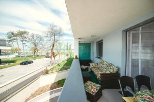 a balcony with couches and a view of a street at D&B Lelle Apartman in Balatonlelle