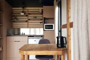 une petite cuisine avec une table en bois et une chaise dans l'établissement Tiny House à la campagne, à Saint-Yan