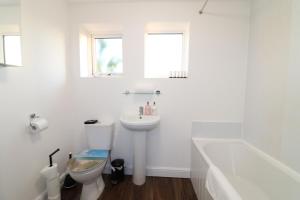 La salle de bains blanche est pourvue d'un lavabo et de toilettes. dans l'établissement Central Modern House, Greenhithe, à Kent