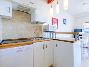 a kitchen with white cabinets and a sink at Studio Eurhostal - Seaview by Interhome in Alcossebre