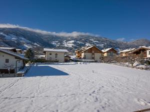 フューゲンにあるHoliday Home Apart Anneliese by Interhomeの家と山々を背景にした雪に覆われた私道