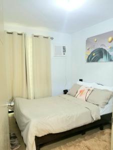 a bedroom with a bed and a painting on the wall at Pine Suites By Crown Asia Family Staycation in Tagaytay
