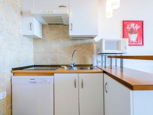 a kitchen with white cabinets and a sink at Studio Eurhostal - Seaview by Interhome in Alcossebre +16 photos