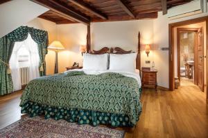 ein Schlafzimmer mit einem Bett mit einer grünen Bettdecke in der Unterkunft Hotel U Prince Prague by BHG in Prag