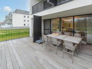 um deque de madeira com uma mesa e cadeiras em Apartment koningstern by Interhome em Bredene