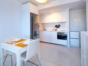 een witte keuken met een witte tafel en stoelen bij Apartment Turquesa Beach-6 by Interhome in Calpe