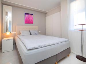 um quarto com uma cama branca e uma pintura rosa na parede em Apartment Turquesa Beach-6 by Interhome em Calpe