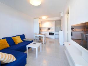 uma sala de estar com um sofá azul e uma cozinha em Apartment Turquesa Beach-6 by Interhome em Calpe