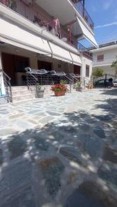 a patio in front of a building with a bench at Ethra luxury studios in Asprovalta