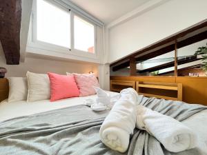 una camera da letto con un letto e asciugamani di Ático Atocha Ile a Madrid