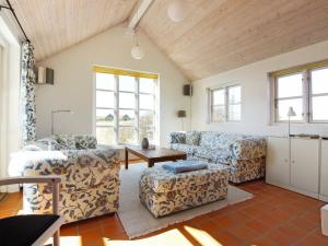 a living room with two couches and a table at Holiday Home Nille - 100m from the sea by Interhome in Skagen