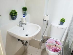 a white bathroom with a sink and a toilet at Pine Suites By Crown Asia Family Staycation in Tagaytay +14 photos